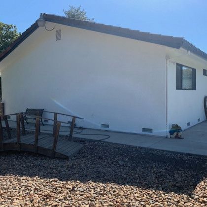 A white house with a wooden bridge in front of it