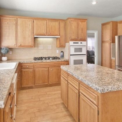 A kitchen with wooden cabinets and granite counter tops