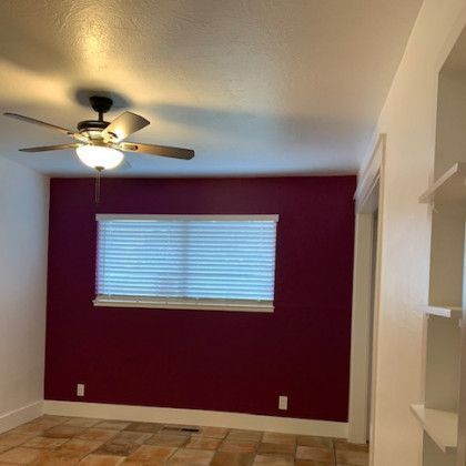 There is a ceiling fan in the corner of the room.