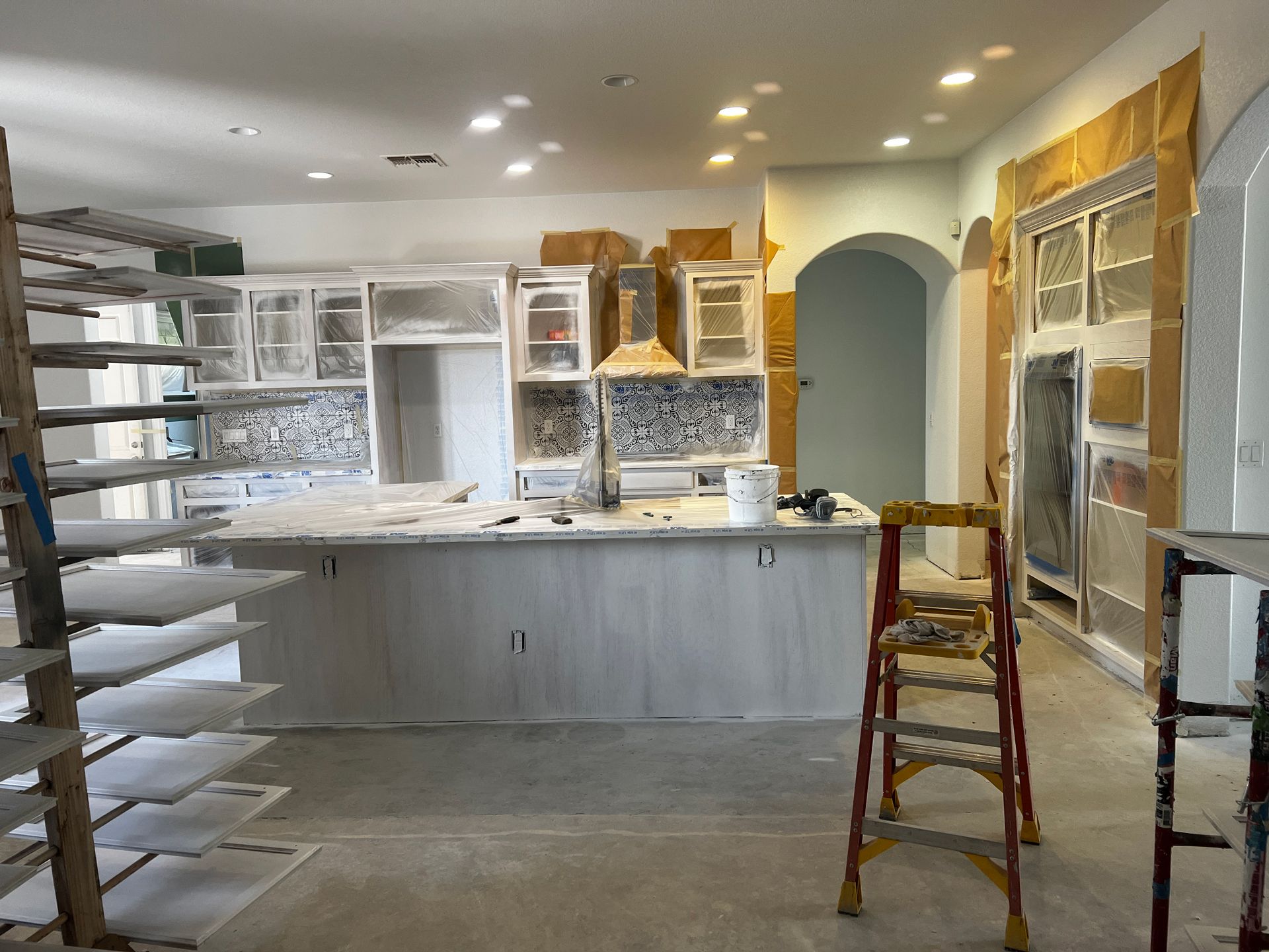 A kitchen under construction with a ladder in the middle of the room
