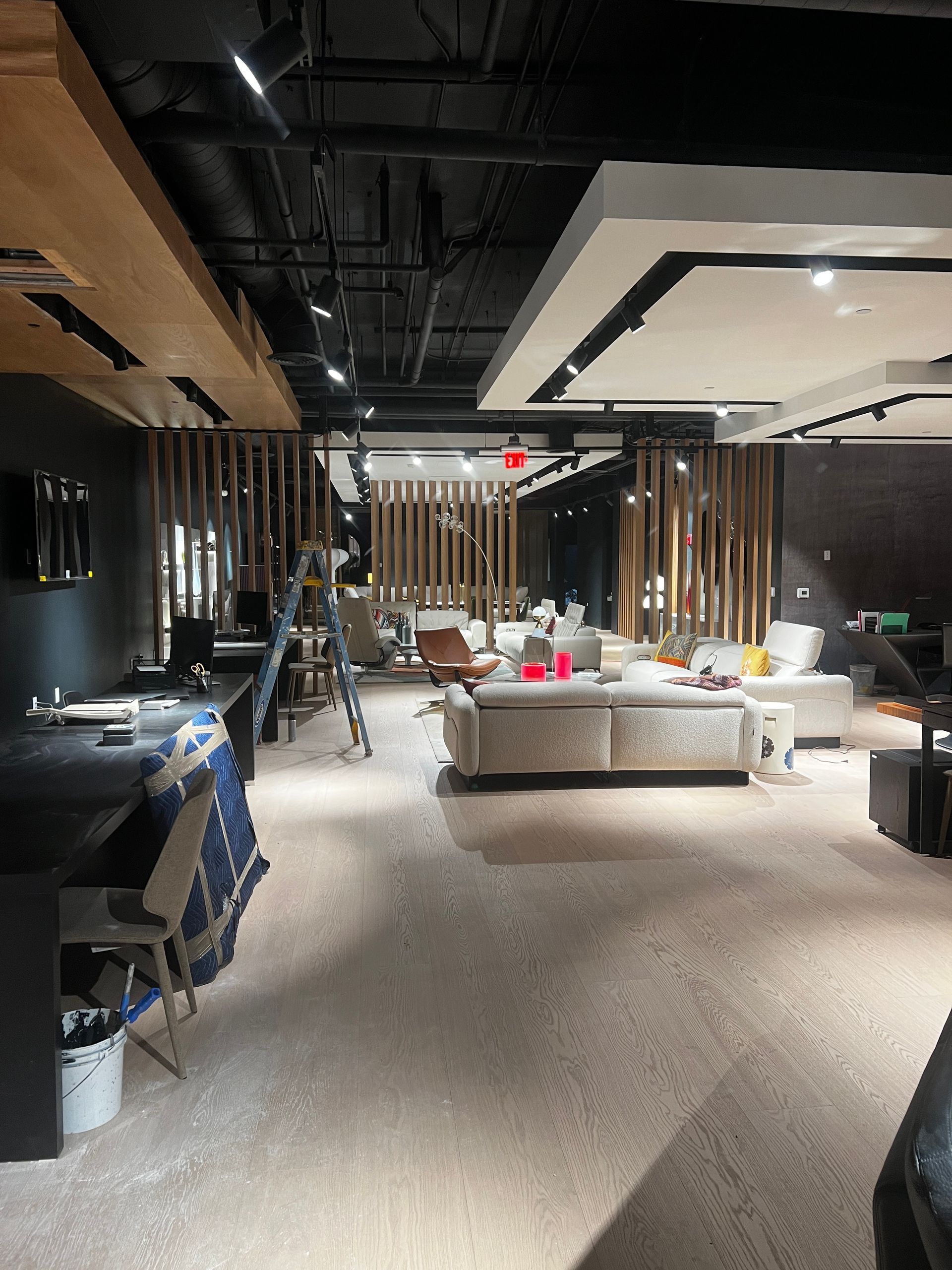 A living room with a lot of furniture and a ladder.