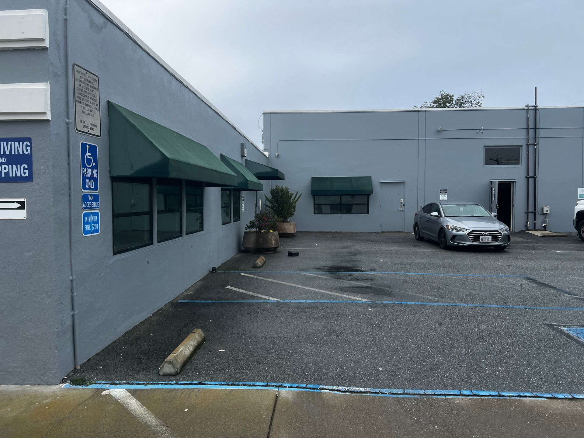 A car is parked in front of a building with a sign that says parking only