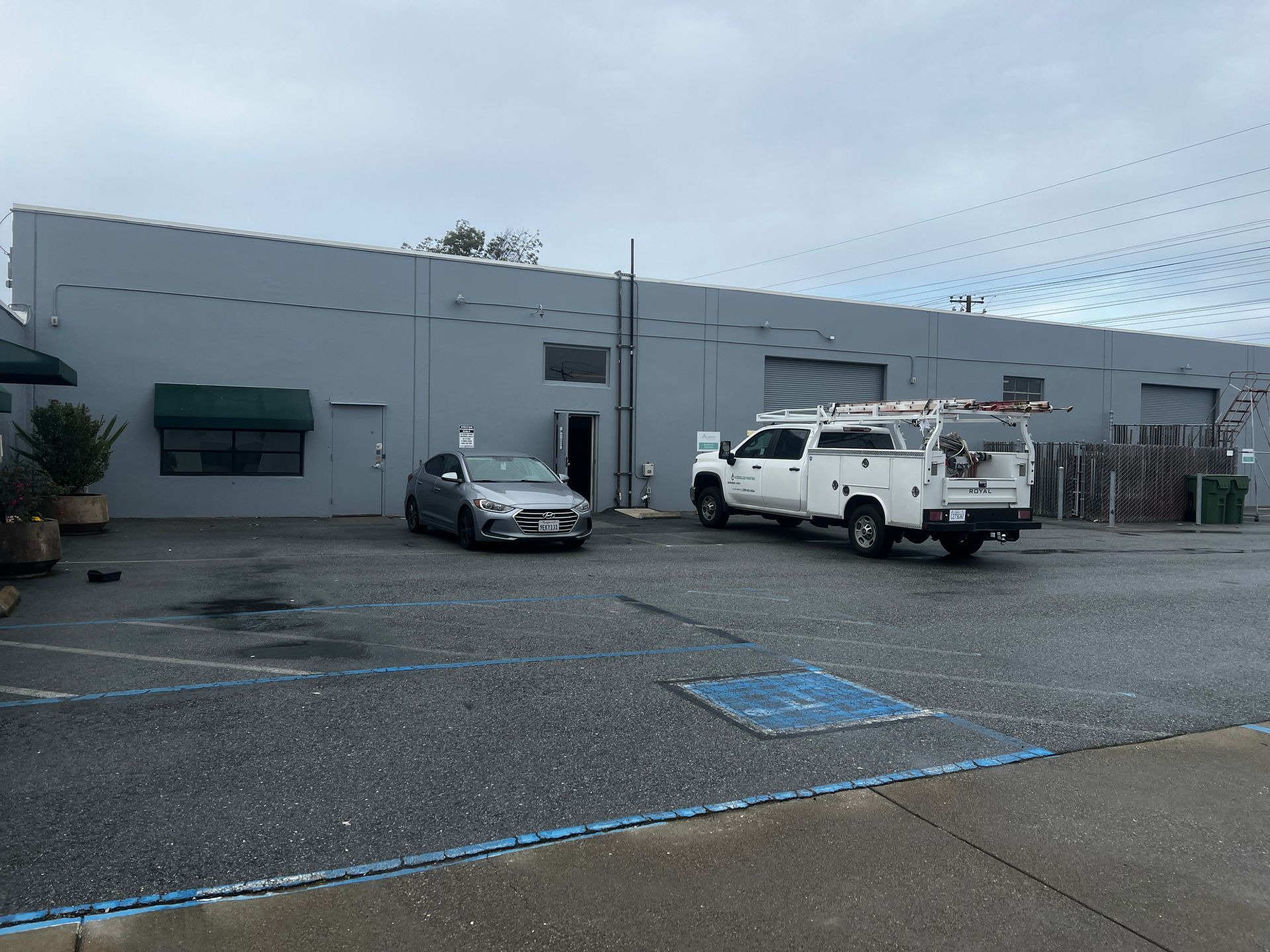 Two white trucks are parked in front of a building.