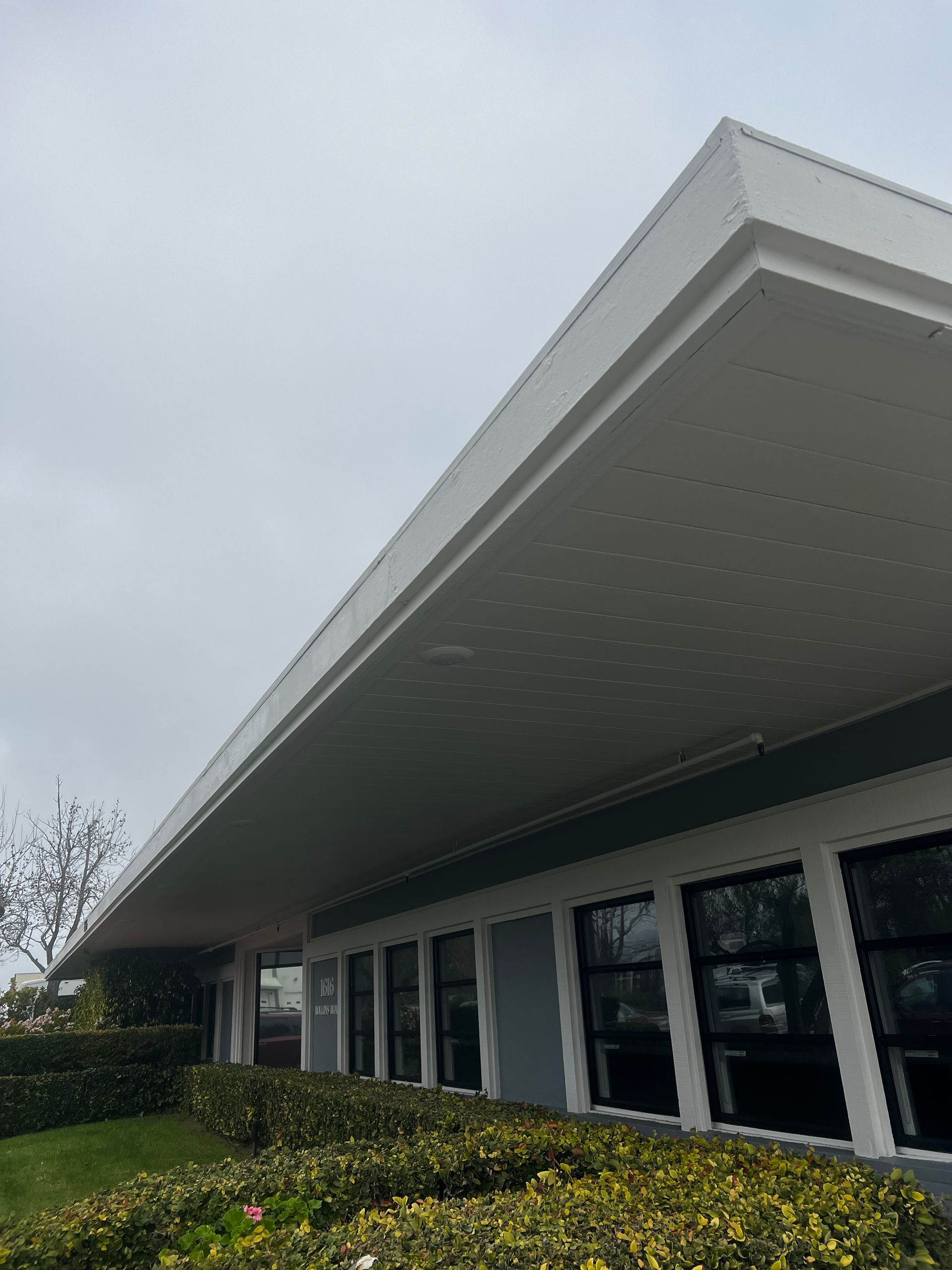 A large white building with a roof and a lot of windows.