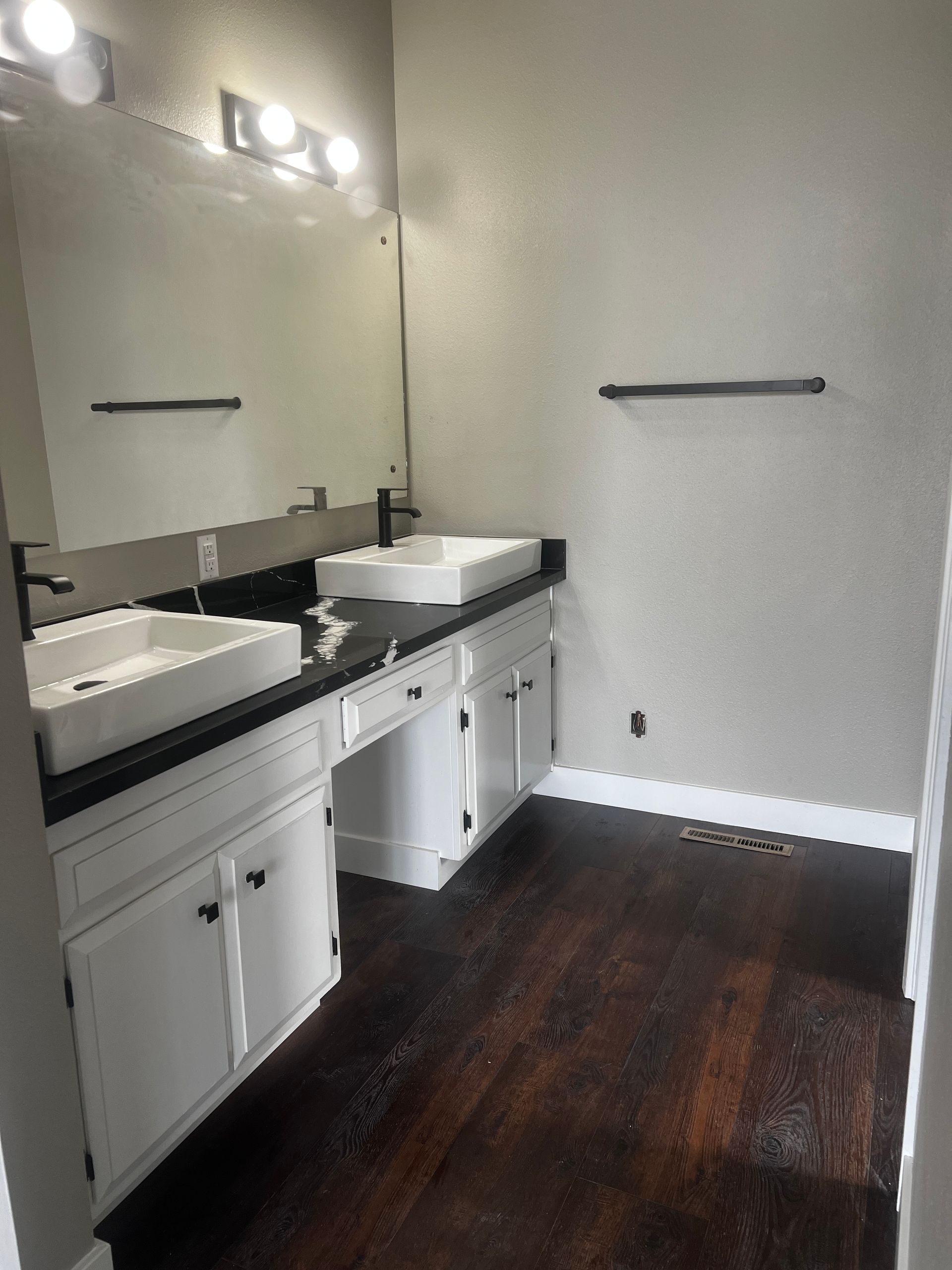 A bathroom with two sinks and a mirror.