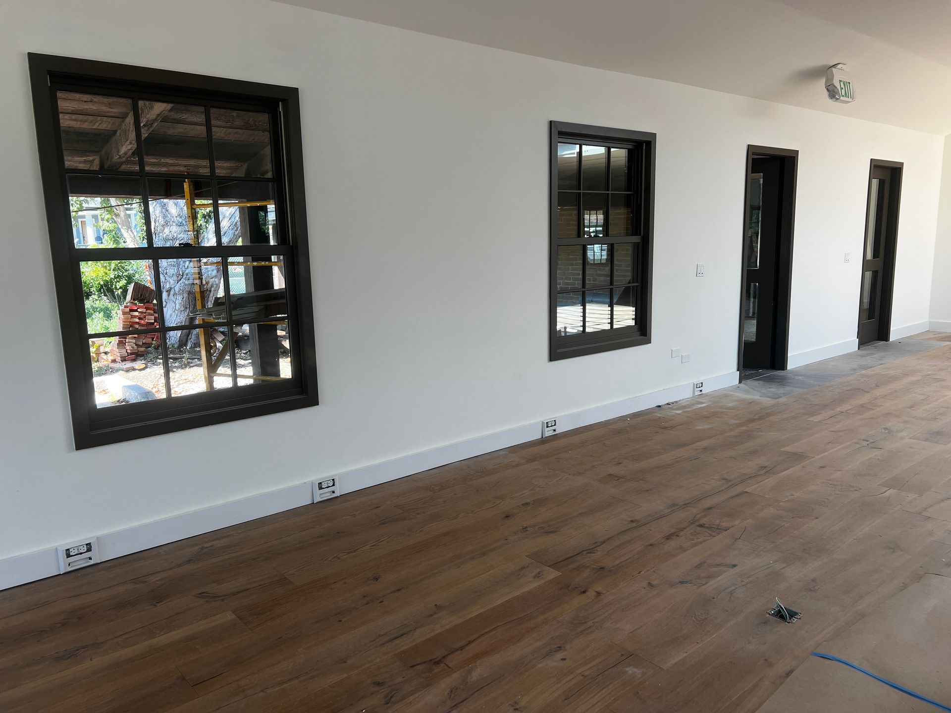 An empty room with hardwood floors and white walls