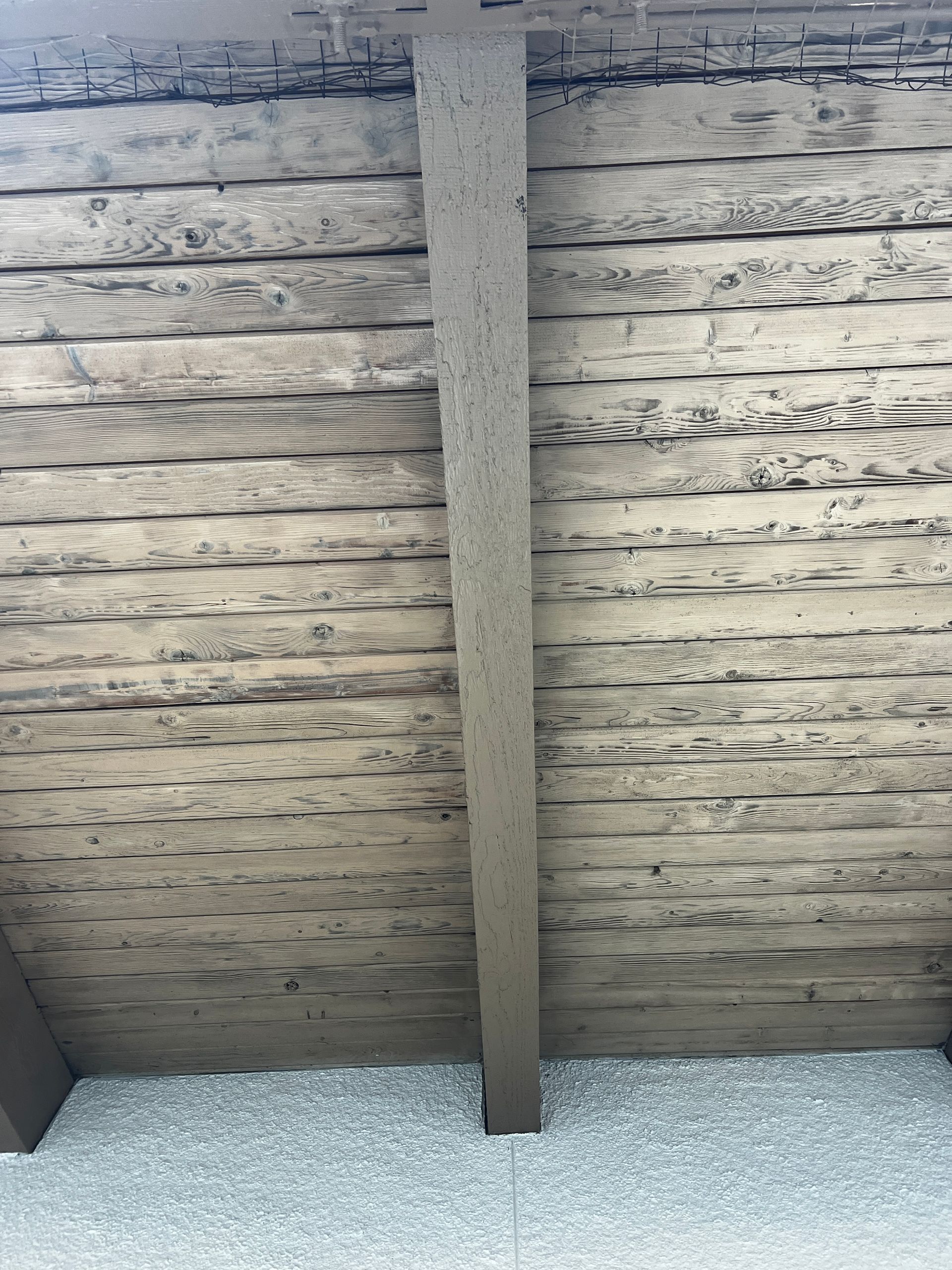 A wooden wall with a beam going through it