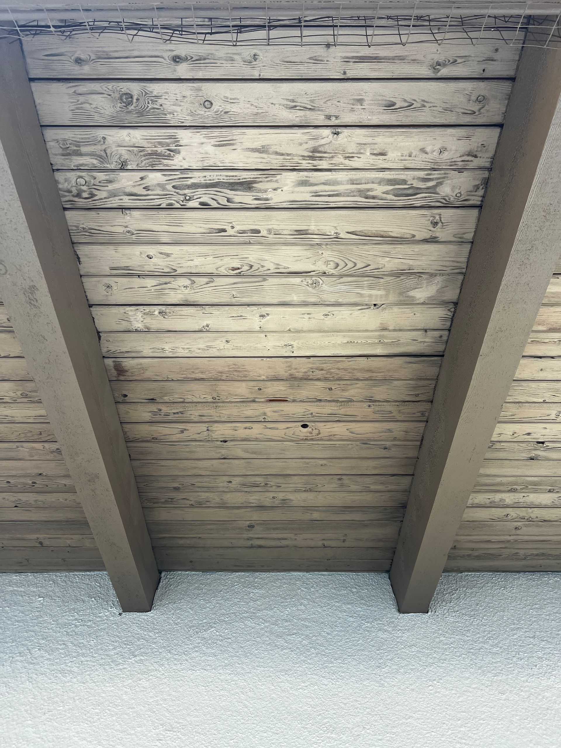 A close up of a wooden ceiling with wooden beams.