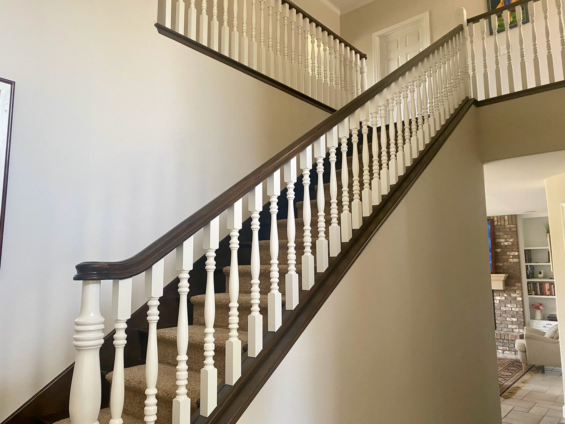 A staircase with a white railing and brown steps in a house