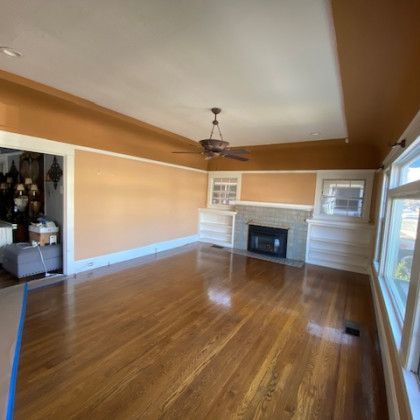 An empty living room with hardwood floors and a fireplace