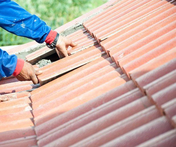 A Man is Installing Tiles on a Roof — Leonard Gray Roof Tiling In Goonellabah, NSW