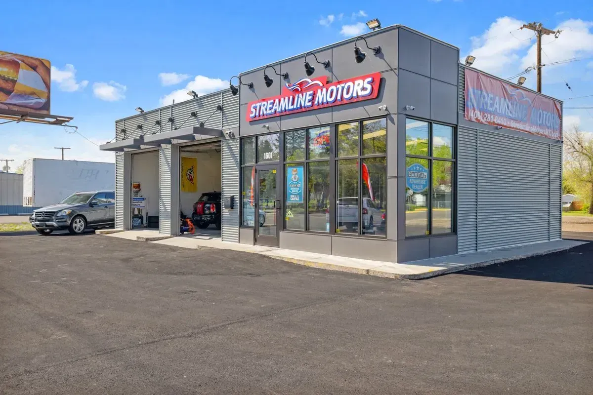 A car is parked in front of a streamline motors car wash.