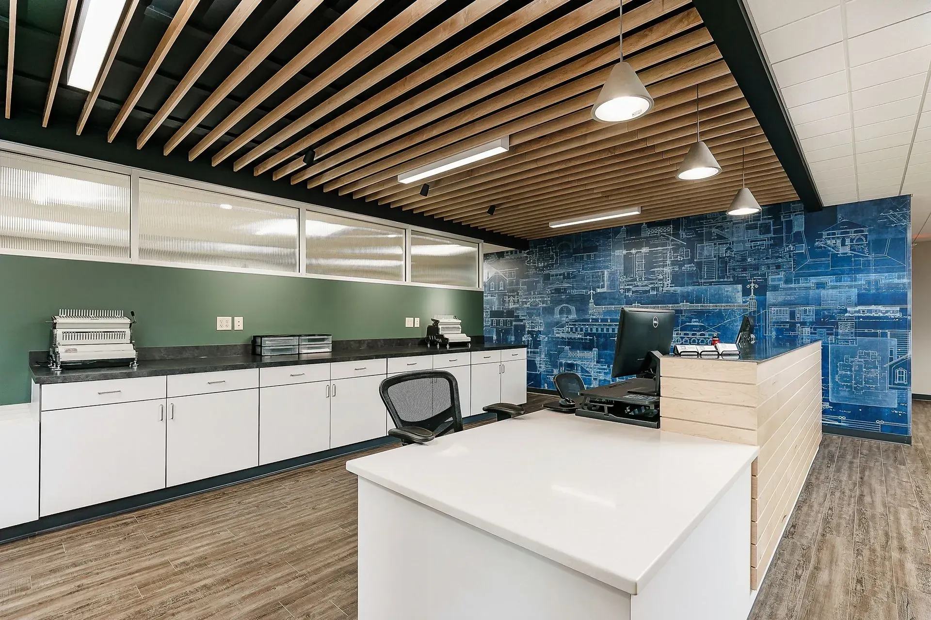 There is a desk in the middle of the room with a computer on it.