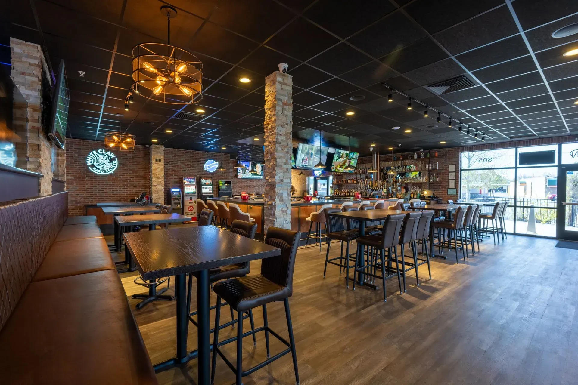 A restaurant with tables and chairs and a bar.