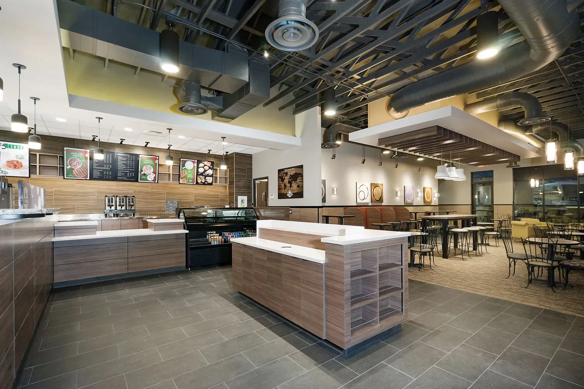 The inside of a restaurant with tables and a counter.