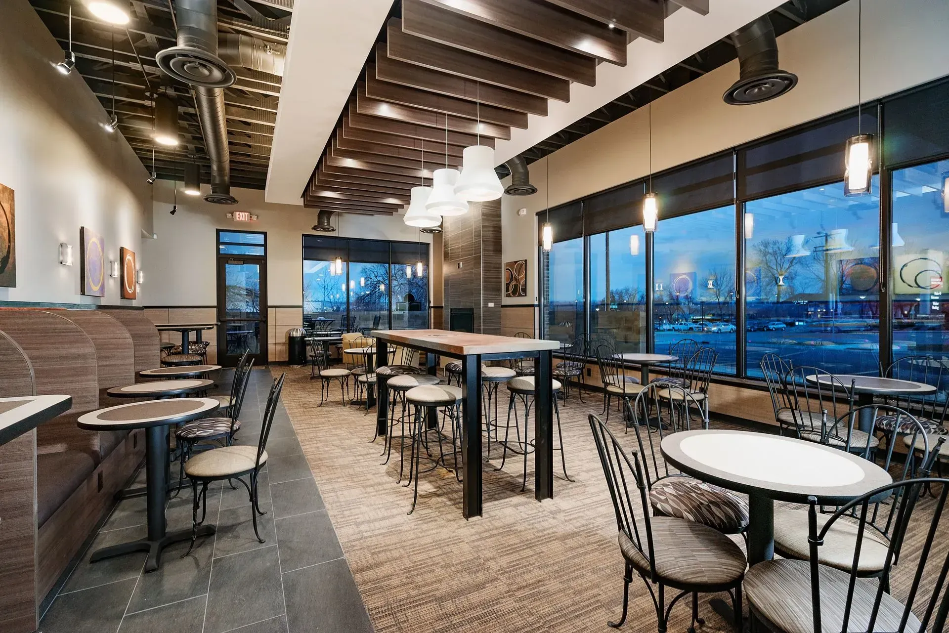 A restaurant with tables and chairs and a lot of windows.