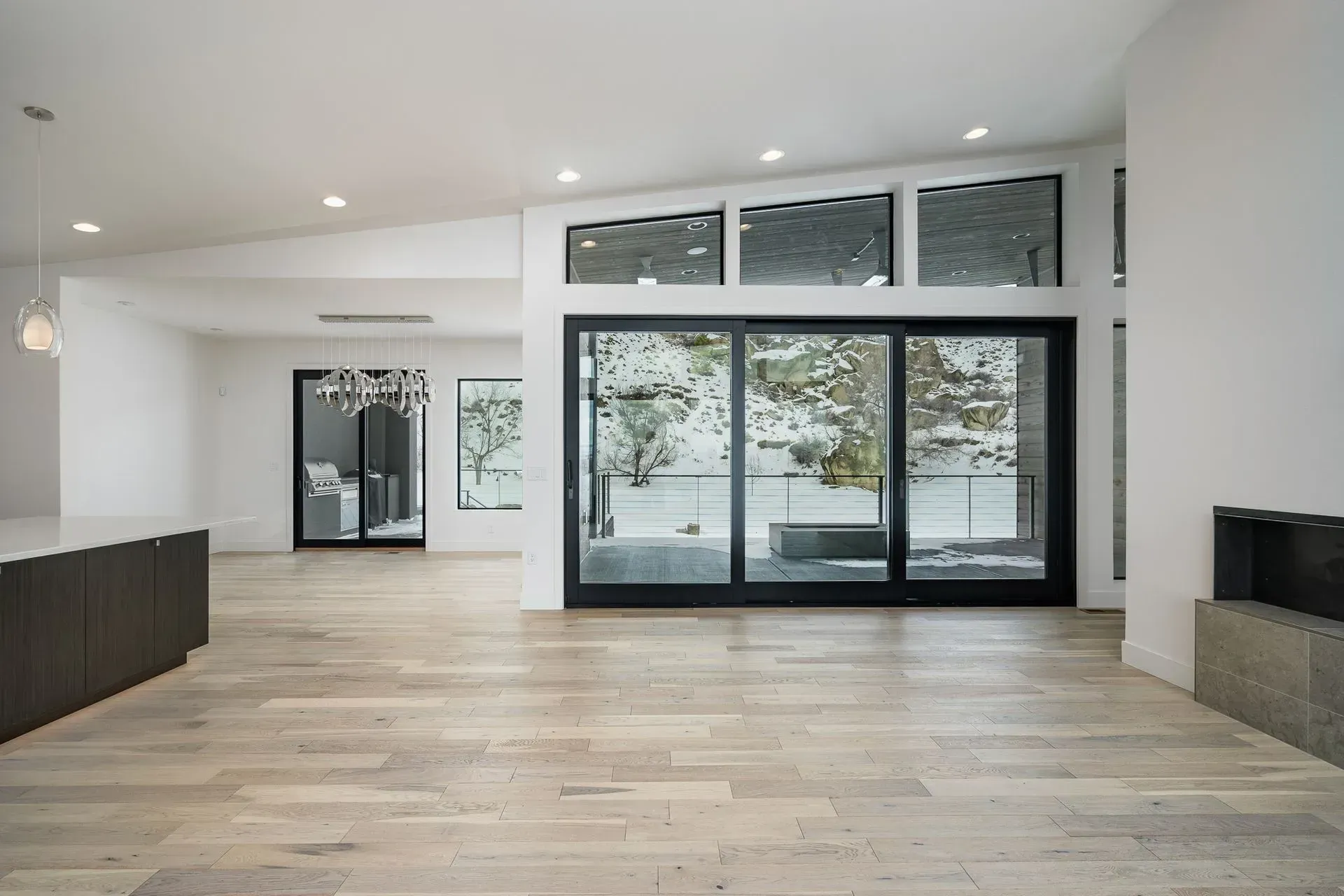 An empty living room with hardwood floors and sliding glass doors.
