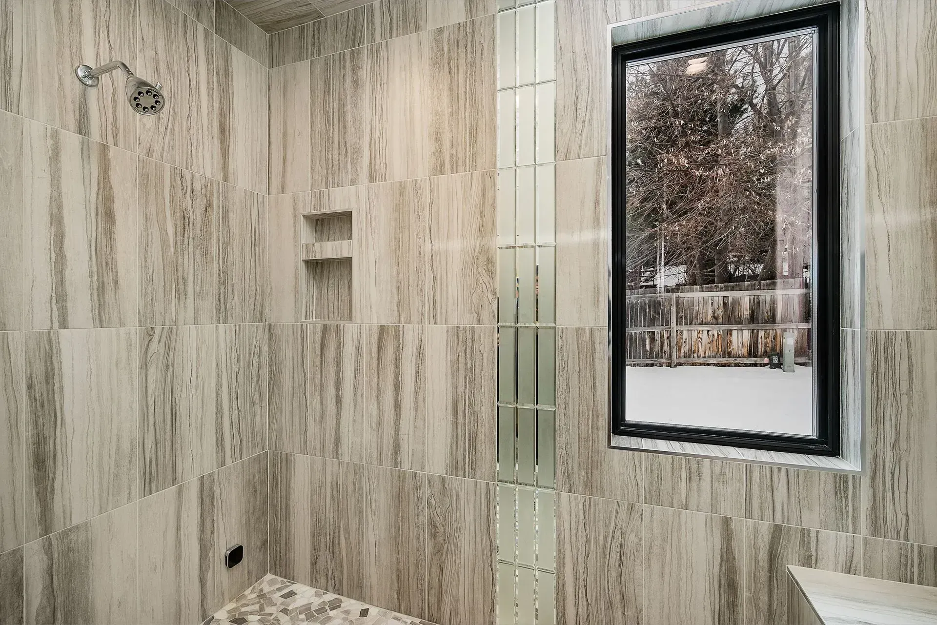 A bathroom with a walk in shower and a window.