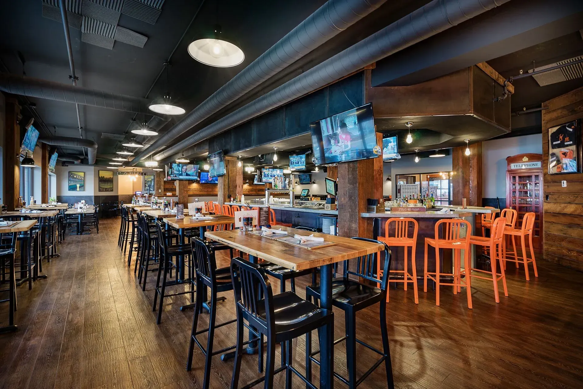 A restaurant with a lot of tables and chairs and a bar.