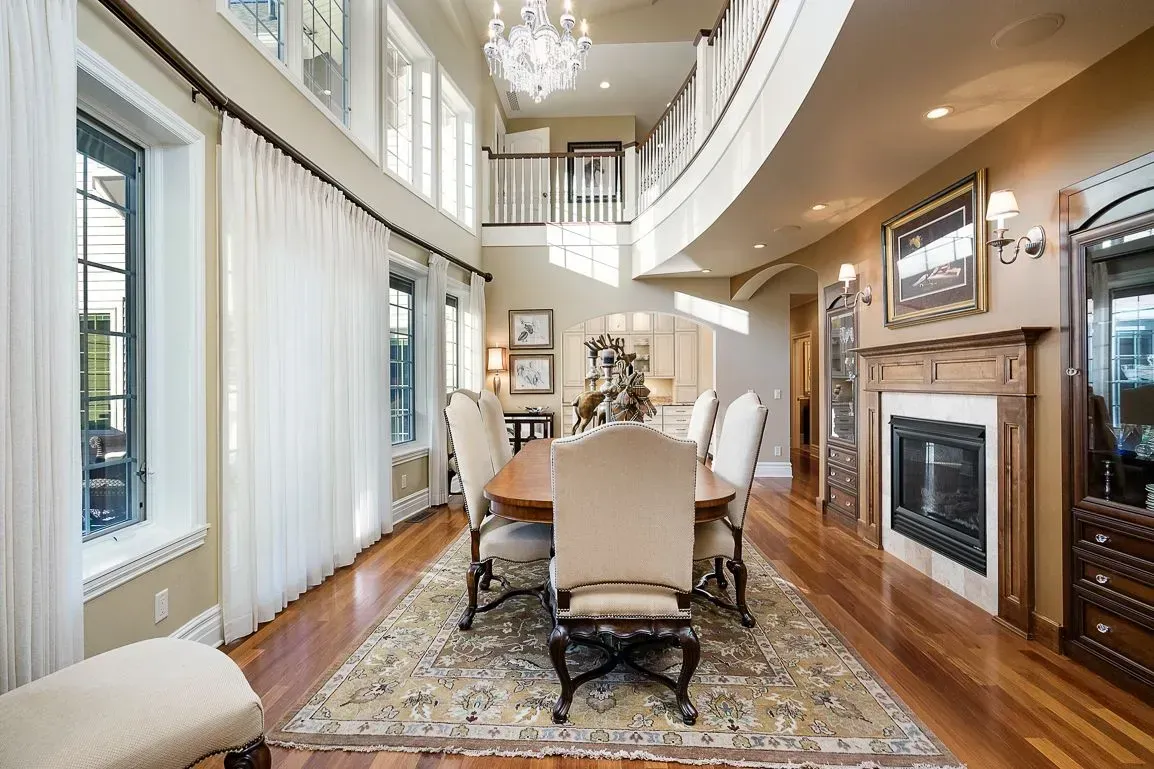 A dining room with a table and chairs and a fireplace