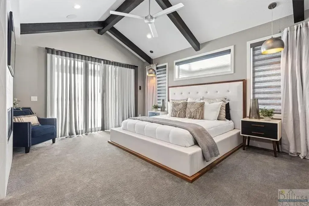 A bedroom with a large bed and a ceiling fan.