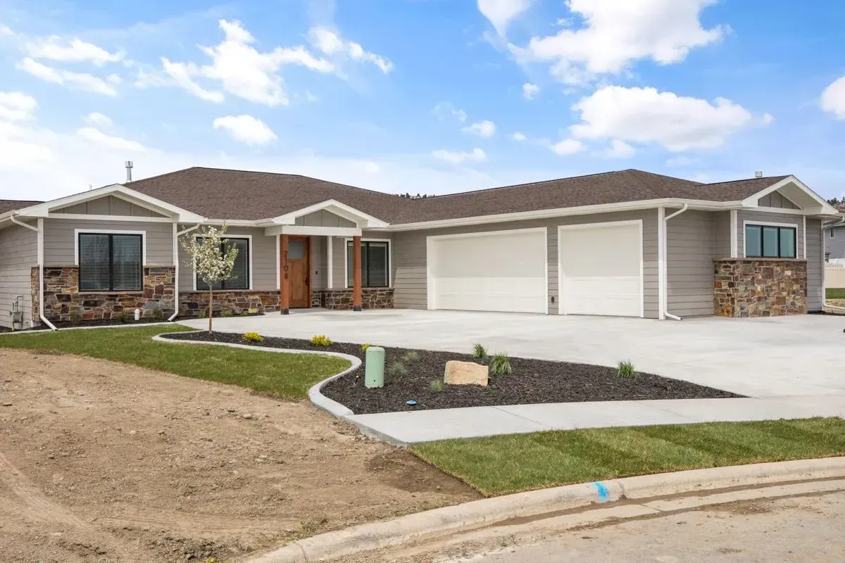 A large house with a lot of windows and a concrete driveway.