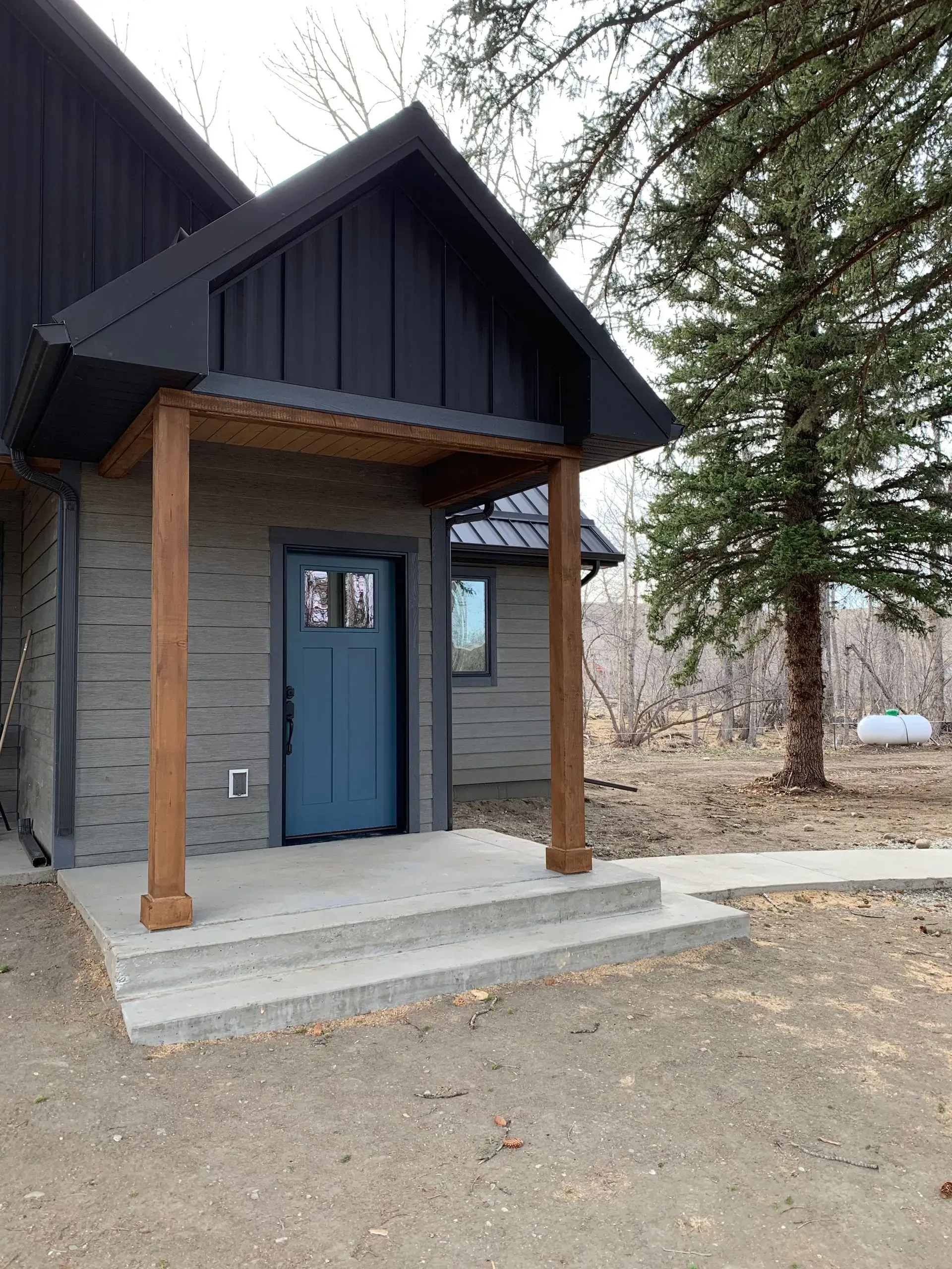 The front of a house with a blue door and a porch.