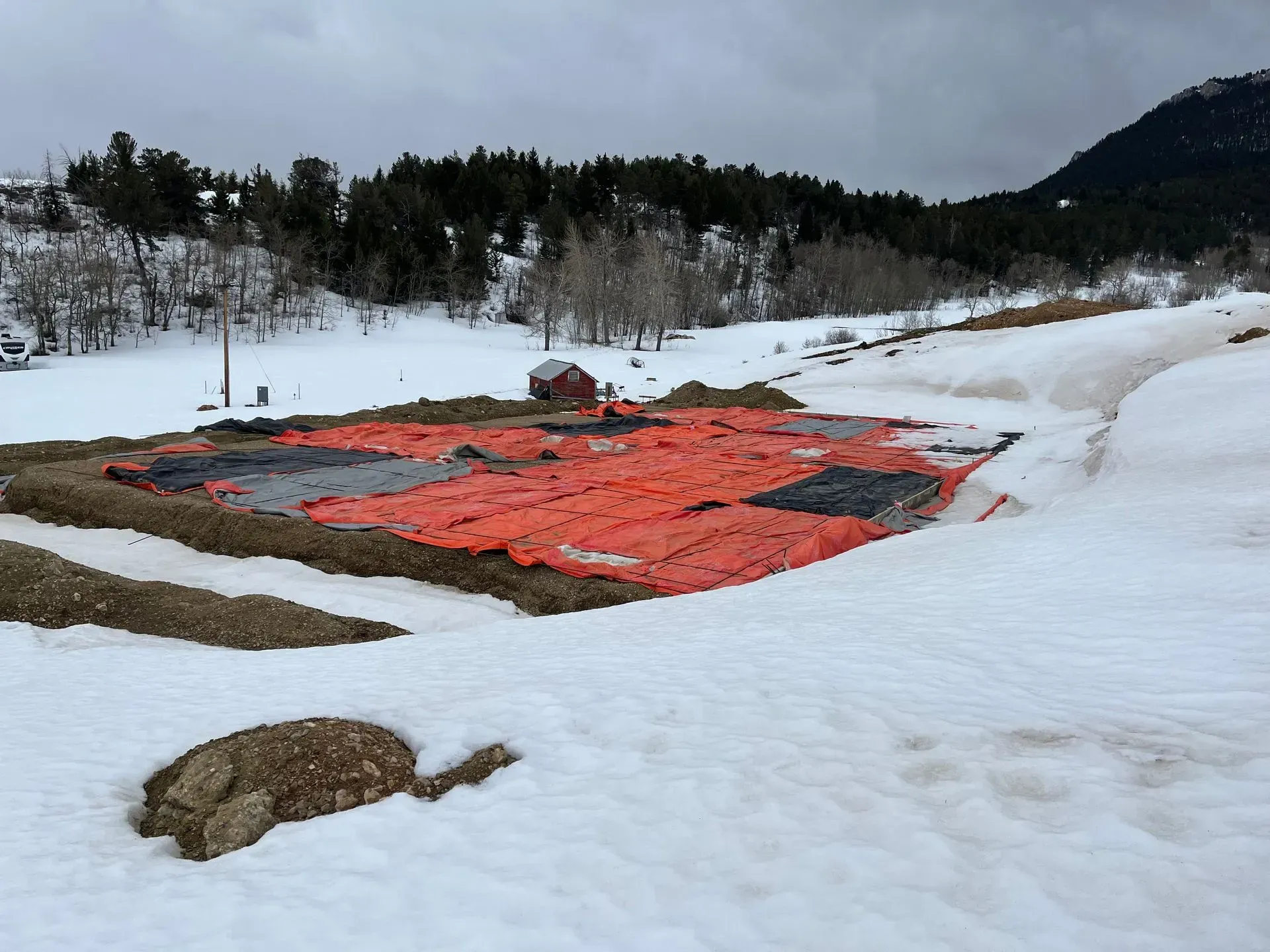 A snowy field with a red tarp in the middle