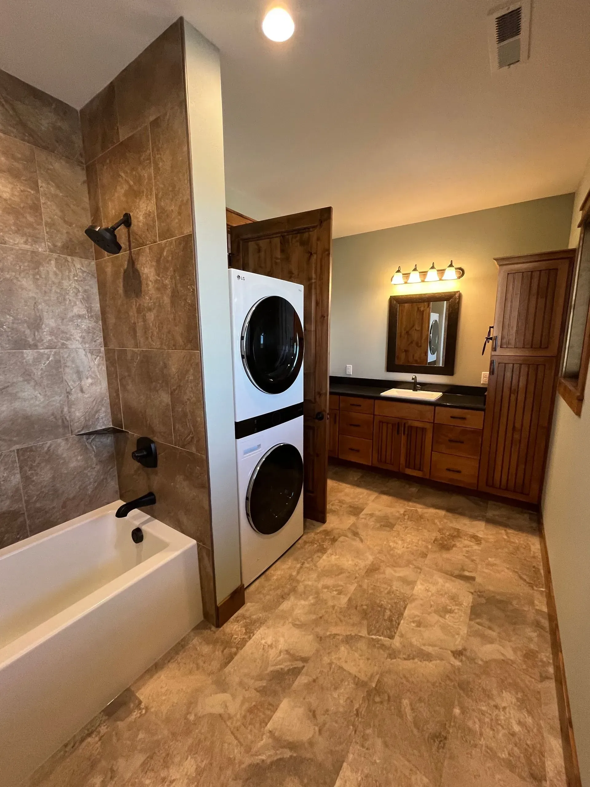 A bathroom with a washer and dryer stacked on top of each other
