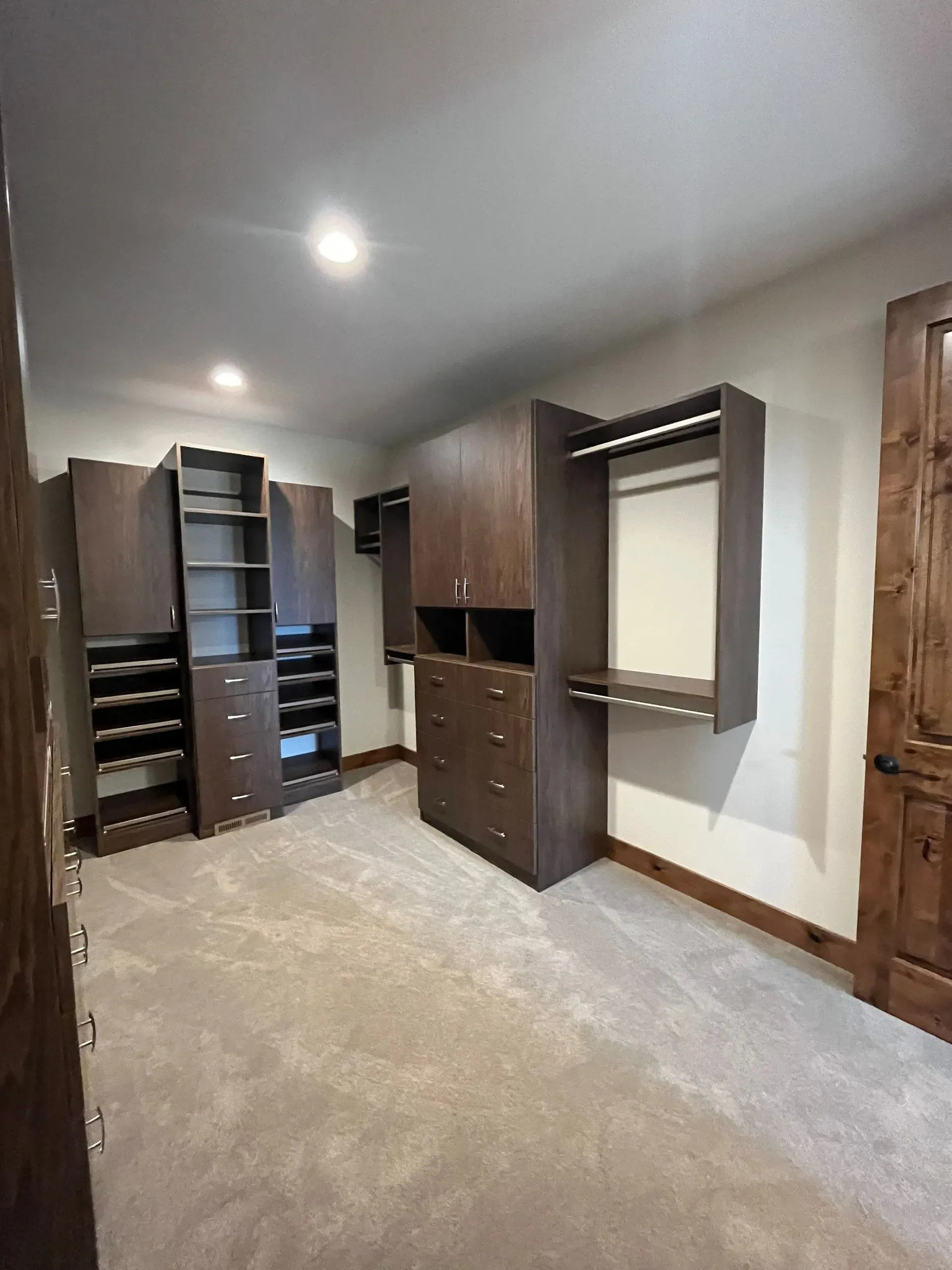 A large walk in closet with lots of cabinets and drawers.