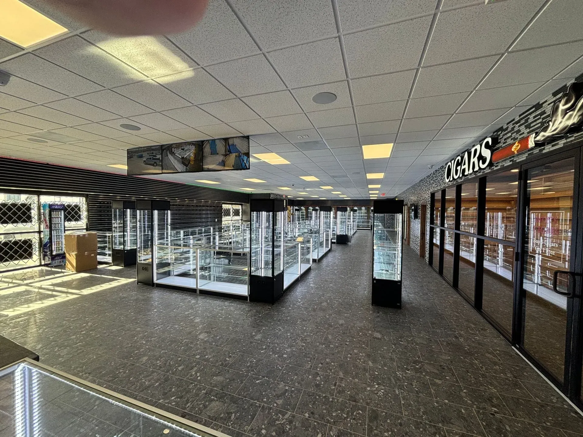 A long hallway filled with lots of glass display cases in a store.
