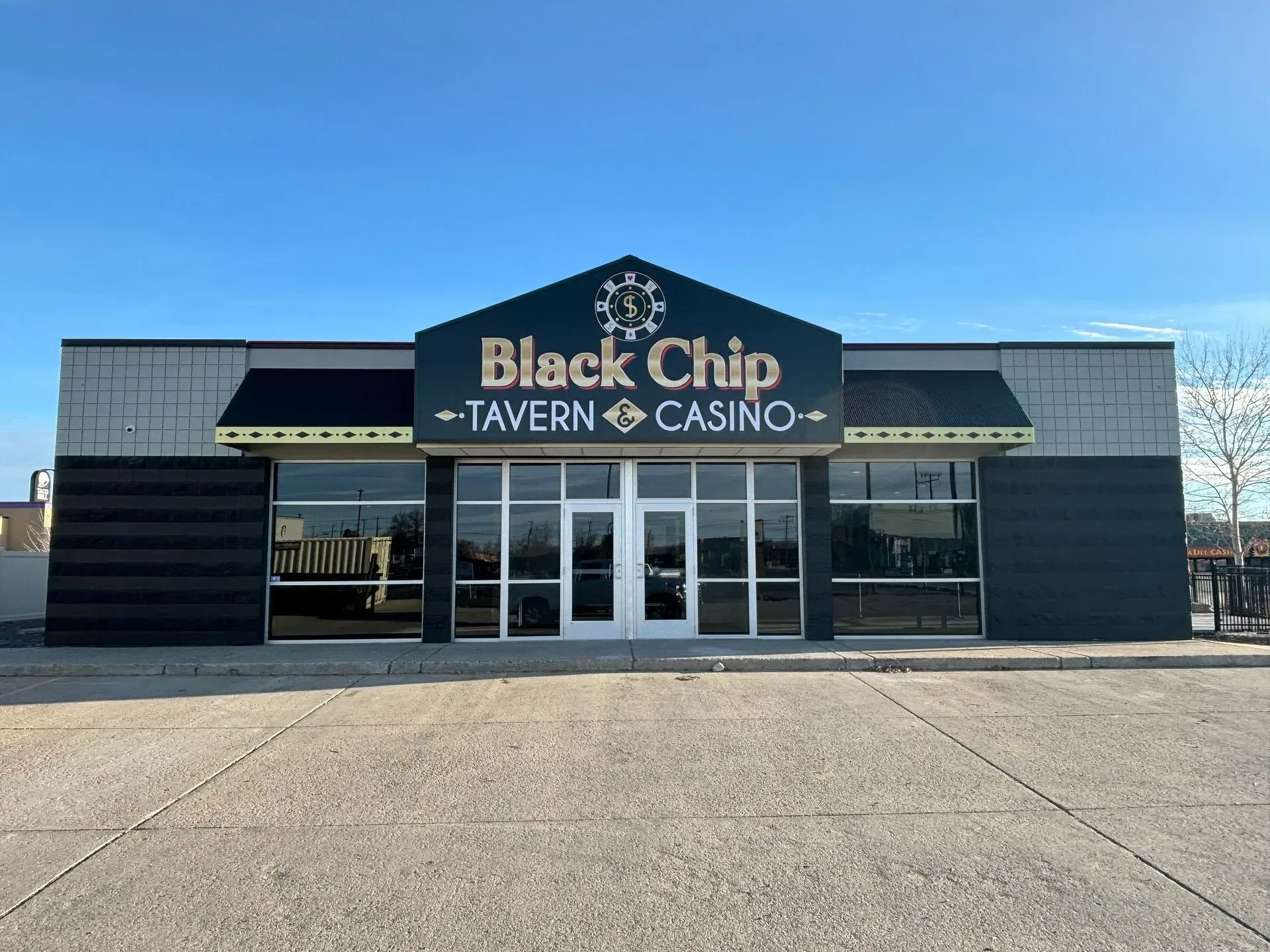 A black chip tavern and casino building with a blue sky in the background
