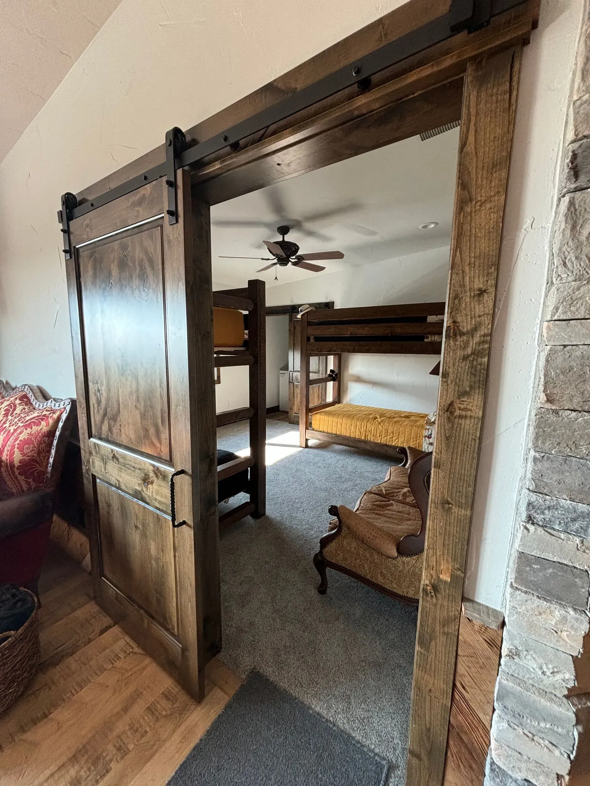A bedroom with bunk beds and a sliding barn door.
