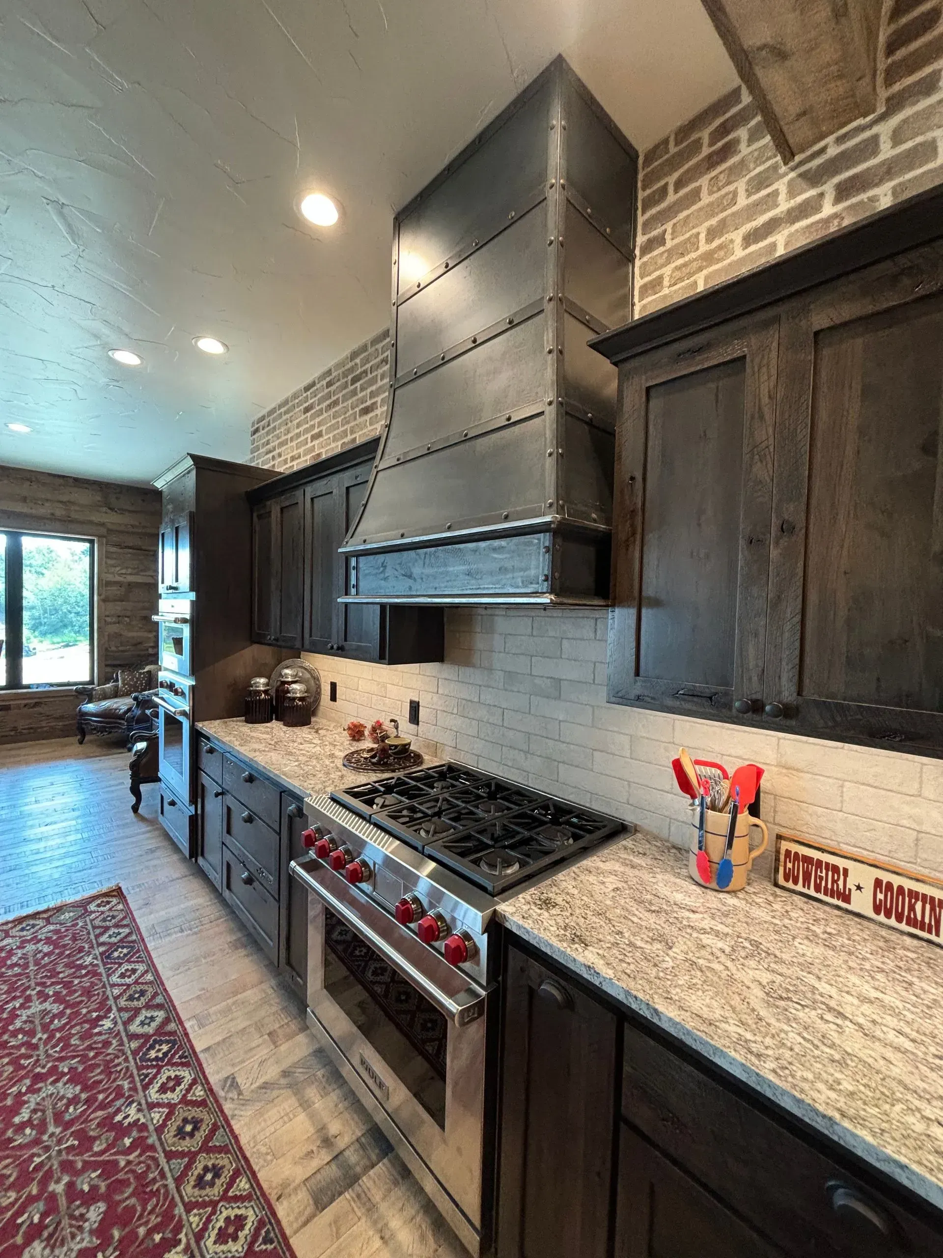 A kitchen with stainless steel appliances , granite counter tops , and wooden cabinets.