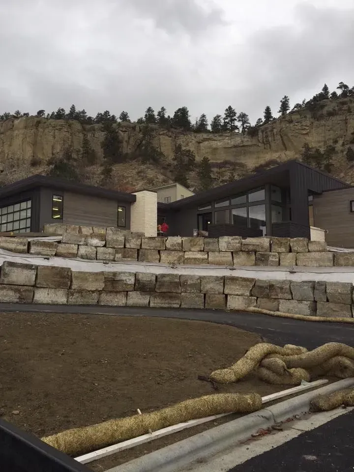 A house on a hill with a lot of rocks in front of it