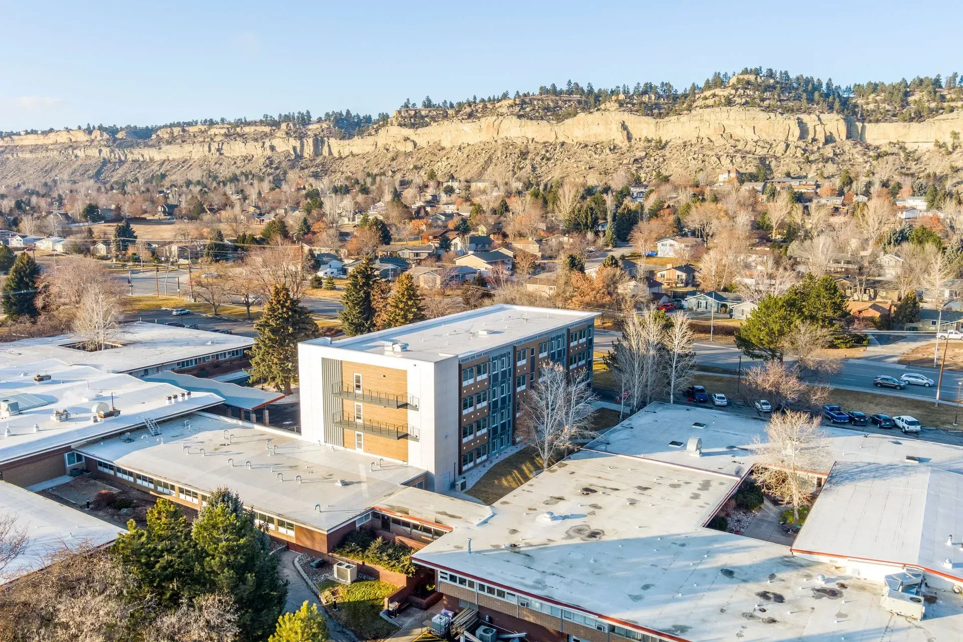 An aerial view of a large building with a mountain in the background.