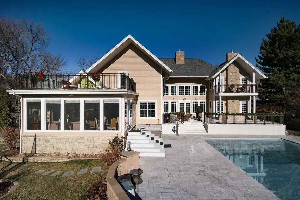 A large house with a swimming pool in front of it