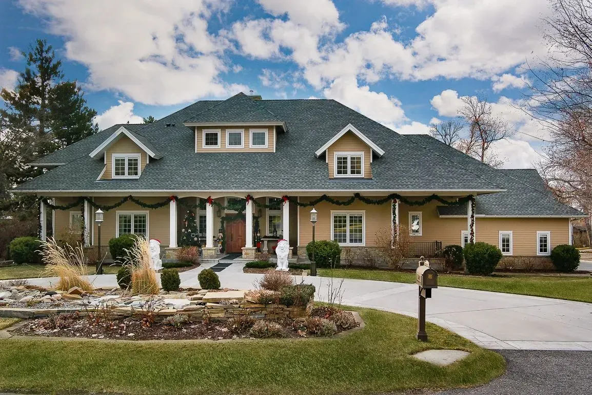 A large house with a blue roof and a driveway