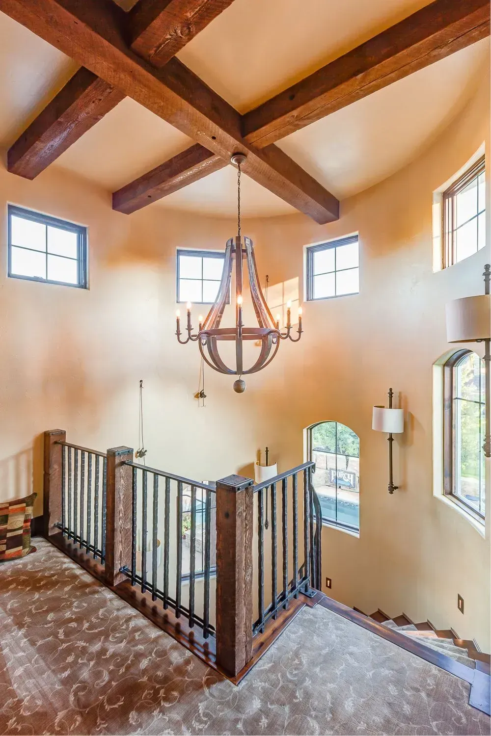 A staircase in a house with a chandelier hanging from the ceiling.
