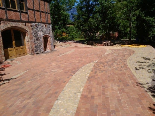 Vor einem Backsteingebäude wird eine Auffahrt aus Backstein gebaut.