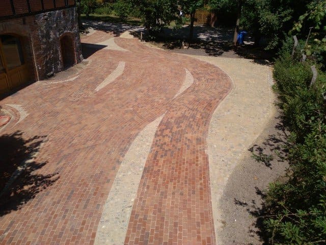 Eine Luftaufnahme einer gepflasterten Auffahrt, die zu einem Haus führt.