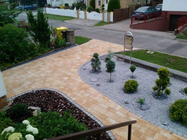 Eine Luftaufnahme eines von Bäumen und Büschen umgebenen Ziegelwegs.