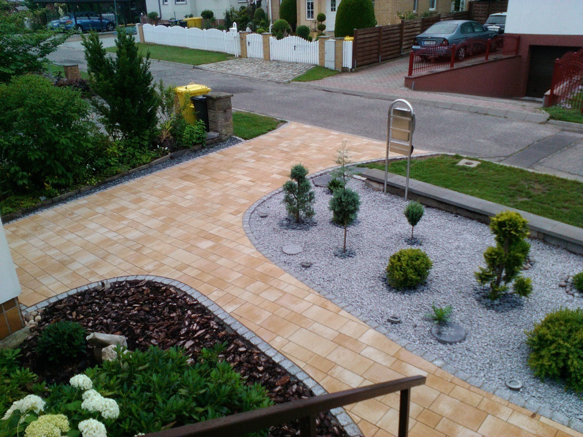 Eine Luftaufnahme eines Gartens mit einem Ziegelweg und einem Briefkasten.