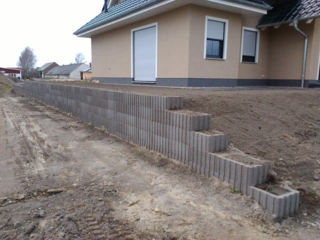 Eine Betonmauer mit Stufen, die zu einem Haus hinaufführen