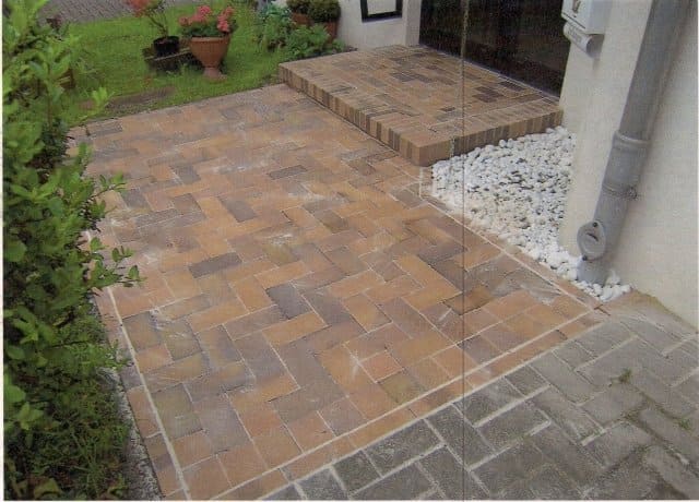 Ein Bild eines gemauerten Gehwegs, der zu einem Haus führt.