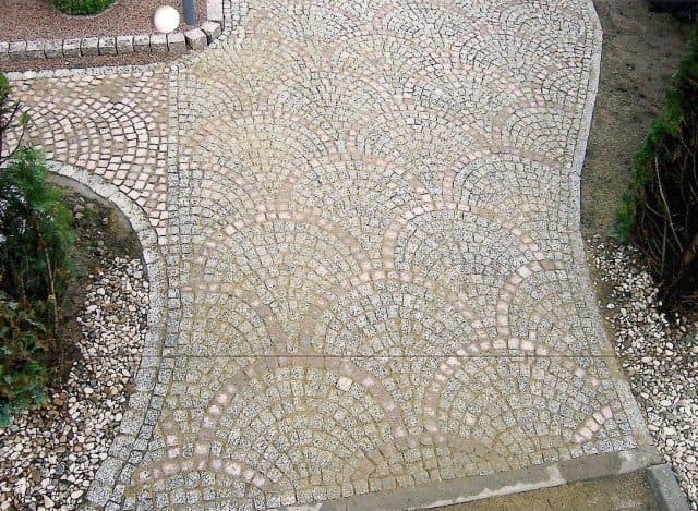 Eine Luftaufnahme eines gepflasterten Gehwegs in einem Garten.