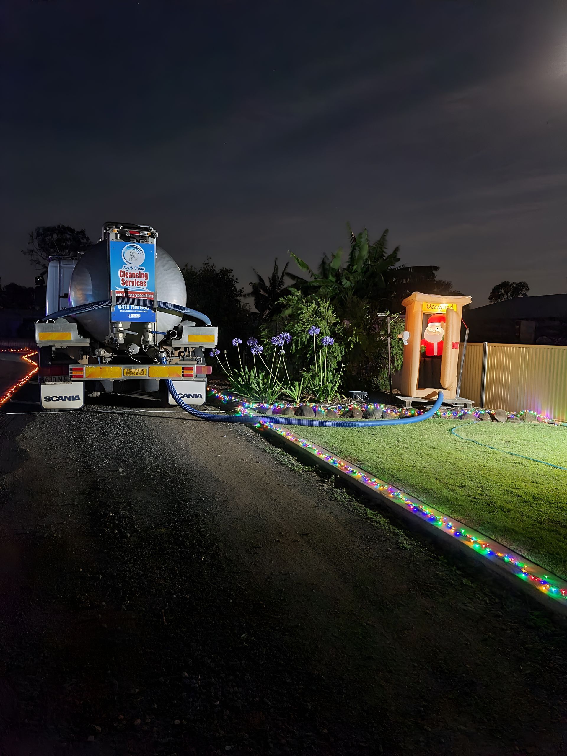 A Water Tanker Parked at Night, Connected to a Christmas Light-lined — Paap's Cleansing Services in Woodgate, QLD