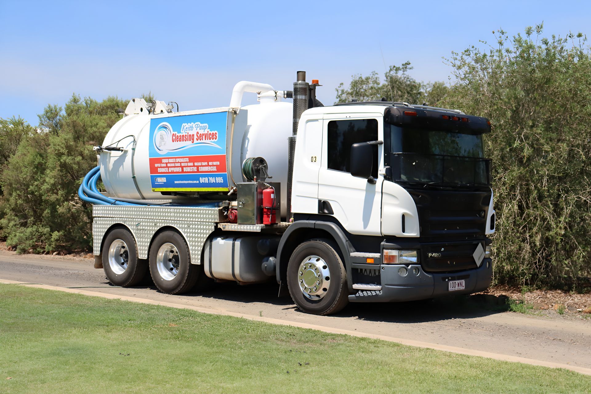 White Septic Tank Truck Parked on a Gravel Road Next to a Grassy Area — Paap's Cleansing Services in Branyan, QLD