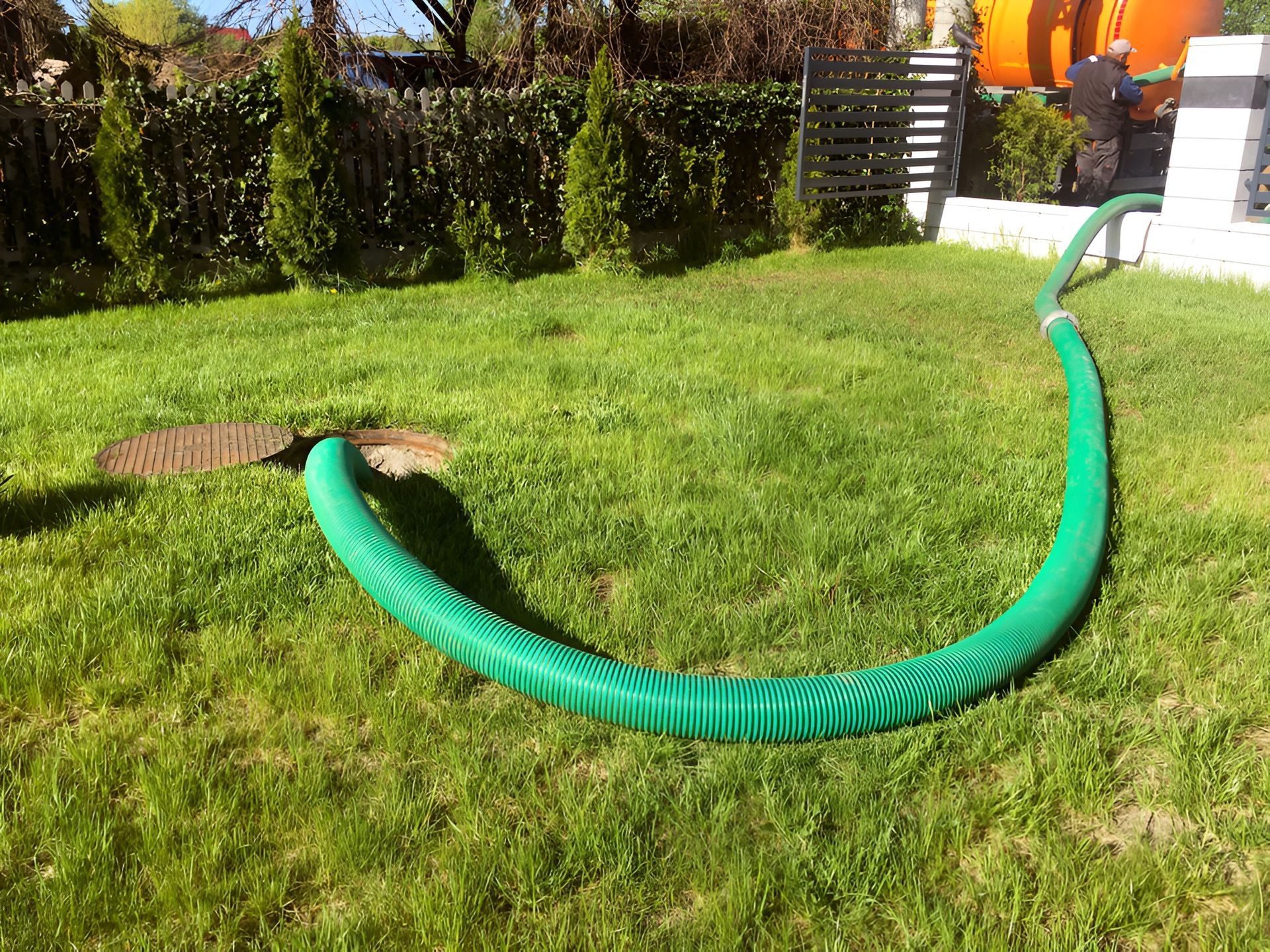 Green Hose Leading From a Manhole on a Lawn — Paap's Cleansing Services in Bargara, QLD