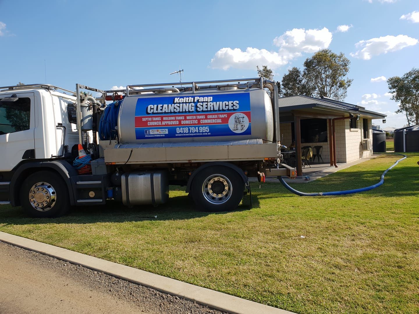 A Sanitation Truck Servicing a Residential Property on a Sunny Day — Paap's Cleansing Services in Branyan, QLD